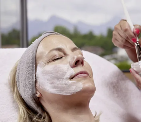 Frau bekommt eine Gesichtsmaske aufgetragen im Hotel Sommer
