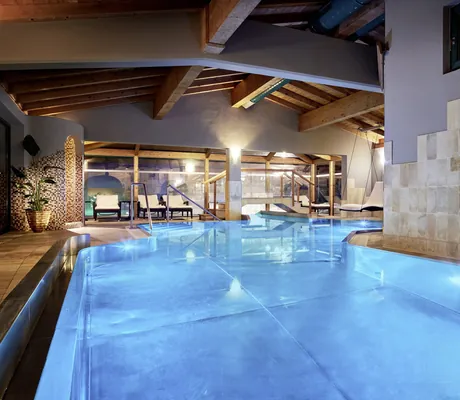 Indoorpool im Böglerhof bei Nacht mit Fischbild an den gekachelten Wänden