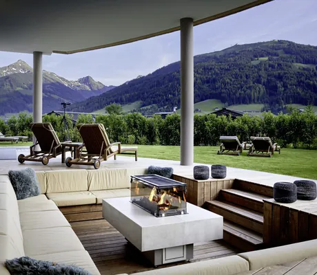 Feuerstelle mit Sitzpolstern auf der Terrasse des Saunabereichs des Böglerhof pure nature spa resort