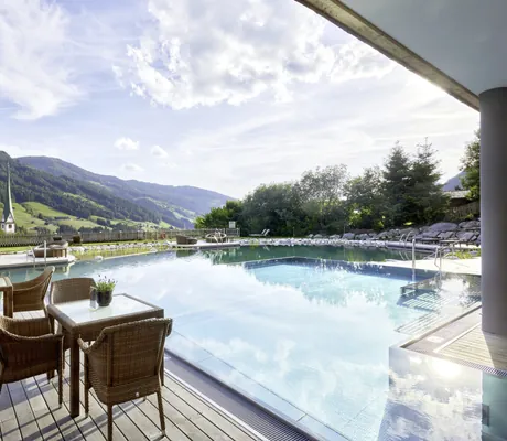 Outdoorbestuhlung am Beckenrand des Outdoorpools im Böglerhof pure nature spa resort