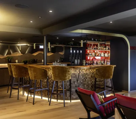 Modern gestaltete Bar mit Barhockern im Hotel Franks