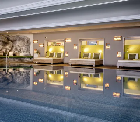 Indoorpool mit breiten Ruheliegen im Hotel Franks