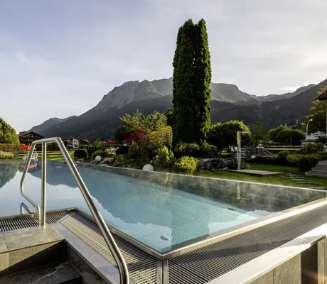 Outdoor-Infinitypool des Hotel Franks mit Bergen im Hintergrund