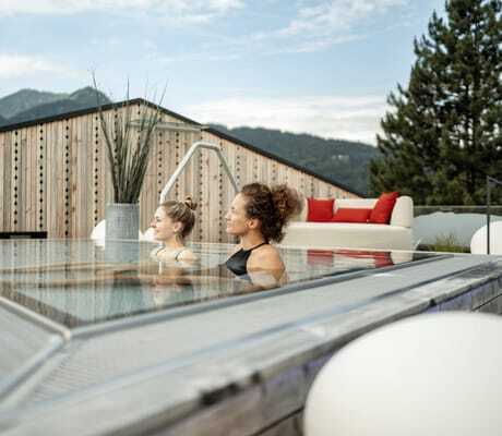 zwei Frauen sitzen im Onsenpool auf dem Rooftop des Hotel Franks