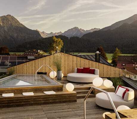 Rooftop-Spa des Hotel Franks mit Onsenpool und runden Daybeds und Bergpanorama im Hintergrund