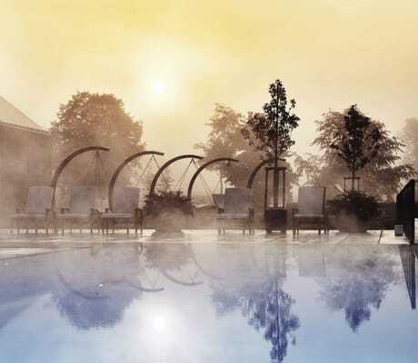 Outdoorpool im Öschberghof bei Sonnenaufgang mit Nebelschwaden über dem Wasser