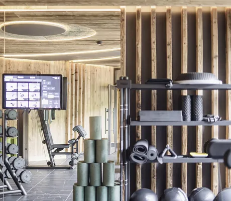 Fitnessraum im Terentnerhof mit Altholzverkleidung und Hantelregal