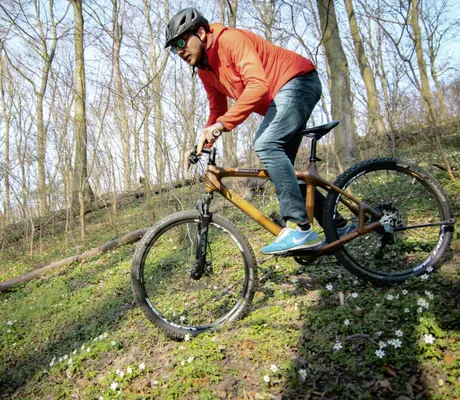 Biker mit roter Jacke und Helm fährt im Bornmühle einen Hang hinunter