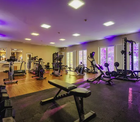Fitnessraum in der Bornmühle mit großen Sprossenfenstern und lila Licht
