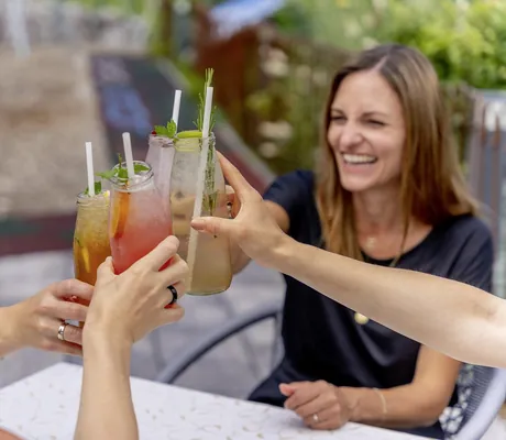 eine Gruppe von jungen Leuten prostet sich in der Riederalm mit Drinks in Flaschen zu