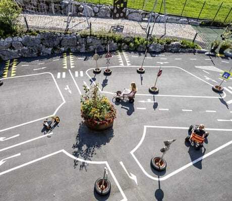 Kinder fahren mit Kinderfahrzeugen im Verkehrspark der Riederalm