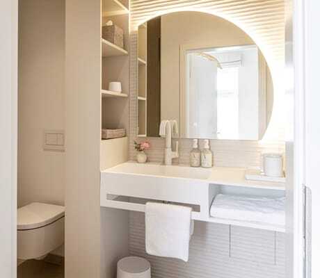 Blick in das moderne Badezimmer in der Villa Astoria mit großem, runden Spiegel