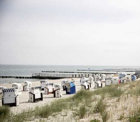 Blick auf einen Strand in unmittelbarer Nähe der Villa Astoria mit zahlreichen Strandkörben und Sanddünen