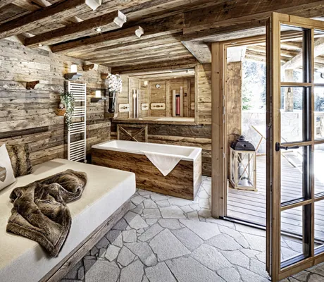 Privater Spabereich in Holzoptik mit Badewanne und gemütlicher Sitzbank im Bergdorf Prechtlgut