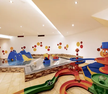 Blick in das Zwergenbad des Familienresort Buchau mit kleiner Kinder-Wasserrutsche und bunter Wasserbahn