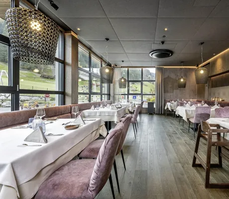 Familienrestaurant in der Riederalm mit rosa Sitzpolstern und KInderstuhl