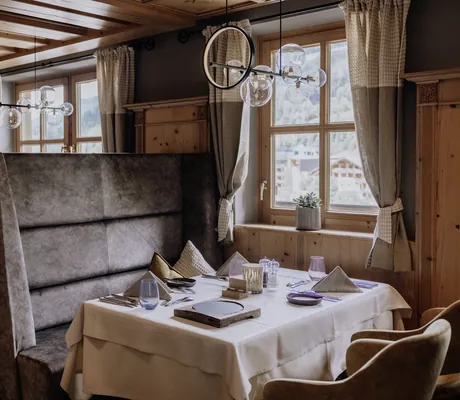 Sitznische im Restaurant der Riederalm mit braunen Hochlehnern
