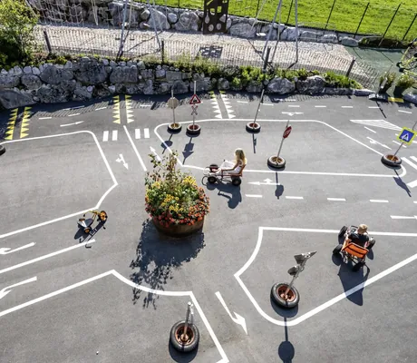 Kinder fahren mit KInderfahrzeugen im Outdoor-Verkehrspark der Riederalm