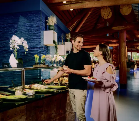 Paar steht am Restaurant-Buffet im Hotel Victory Therme Erding und lächelt sich an
