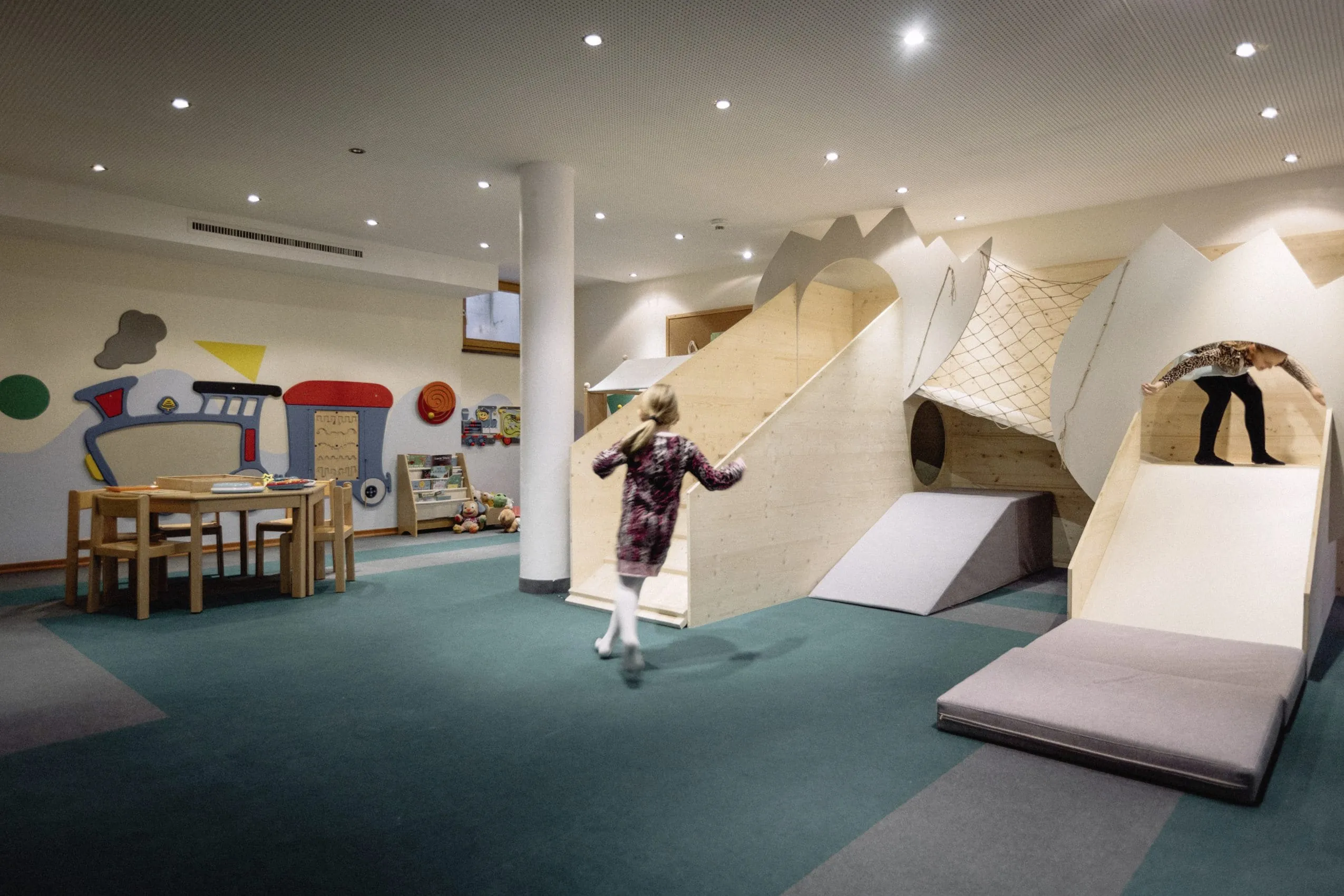 Indoor Kinderspielecke mit Maltischen, Rutsche und B&uuml;cherregal im Bauernhof Hotel Oberschwarzach