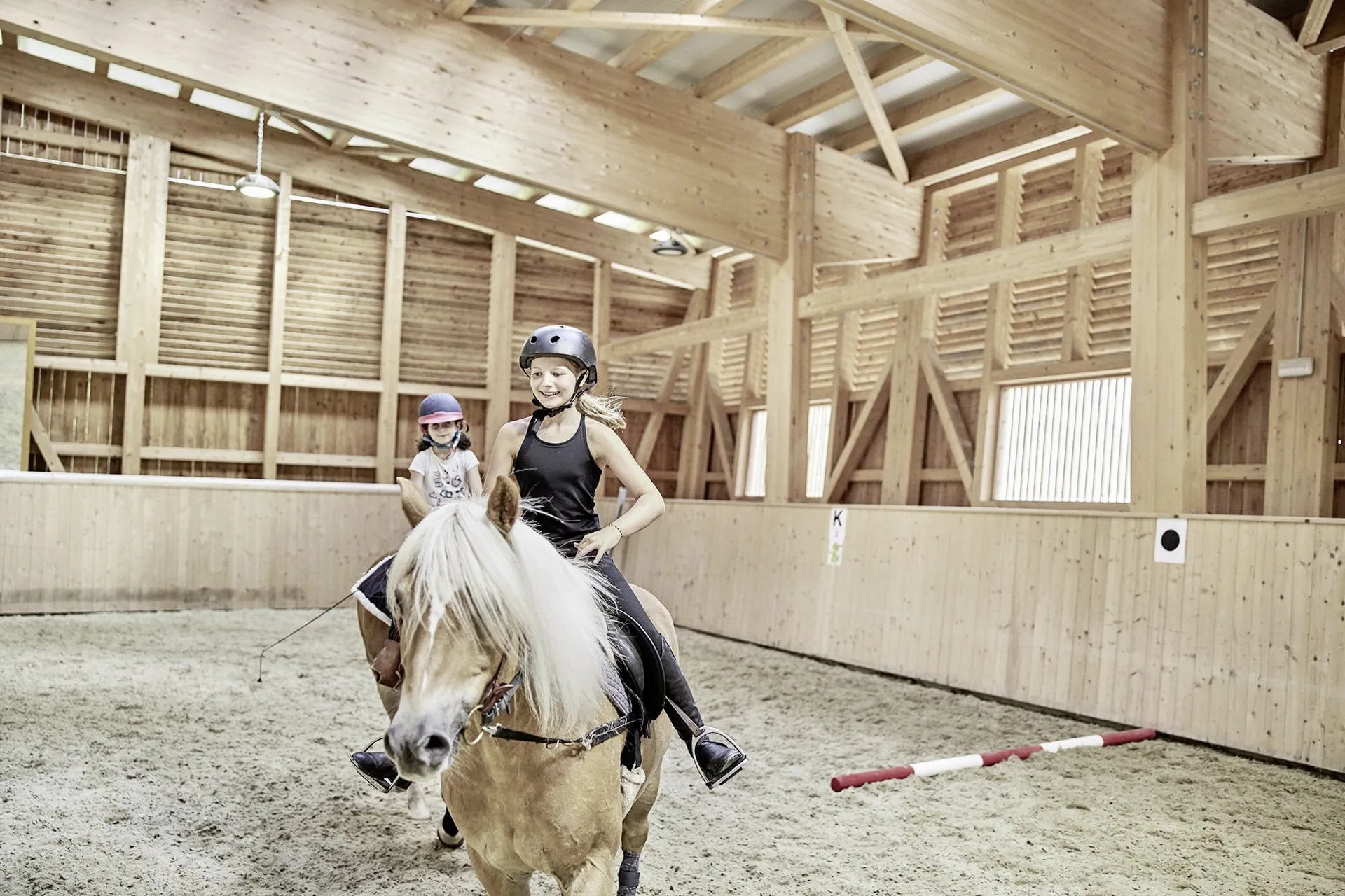 zwei junge Reiterinnen in der Reithalle des Familienresort Buchau