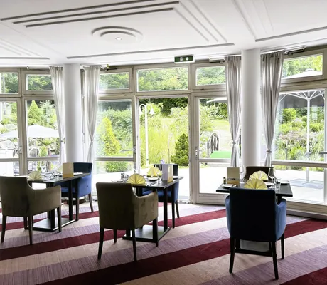 Restaurant mit eingedeckten Zweiertische und BLick in den Garten im Hotel Die Wutzschleife