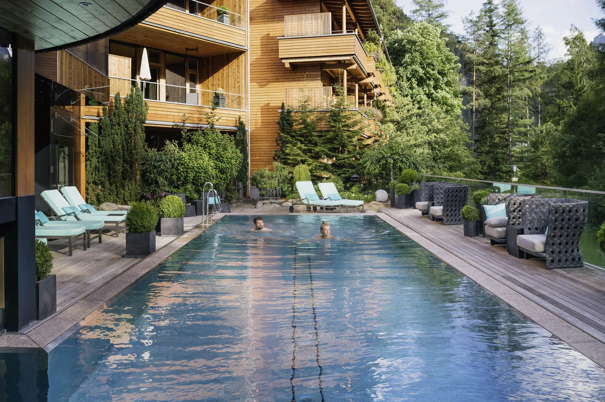 Paar schwimmt im Outdoorpool des Naturhotel Waldklause