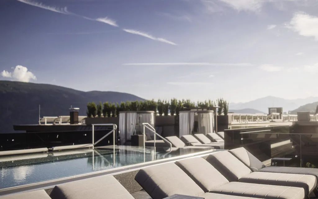 Sonnendach mit Bergblick, Pool und zahlreichen Liegen zum Sonnenbaden im Sporhotel in S&uuml;dtriol