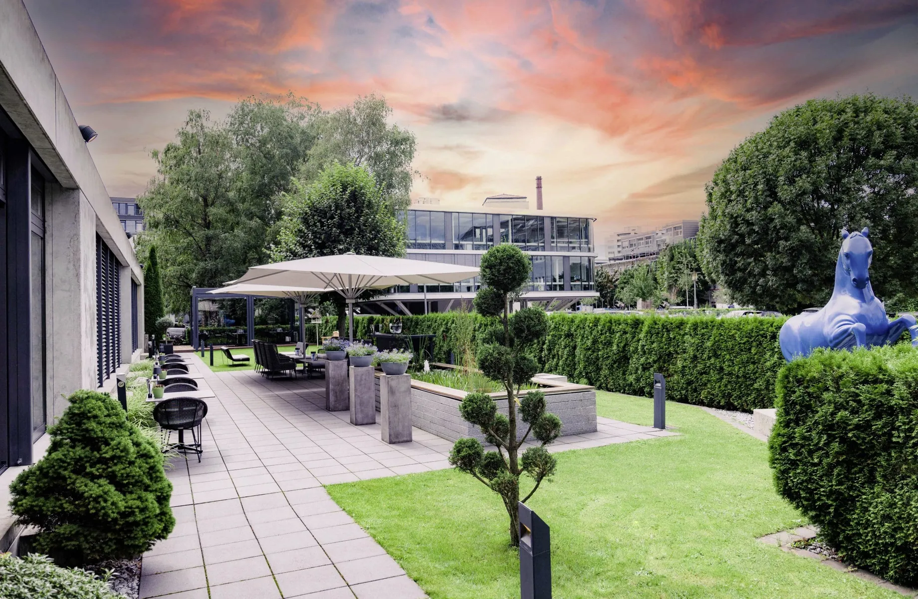 Terrasse mit Statue von Blauem Pferd vor Abendhimmel im Hotel Der Blaue Reiter