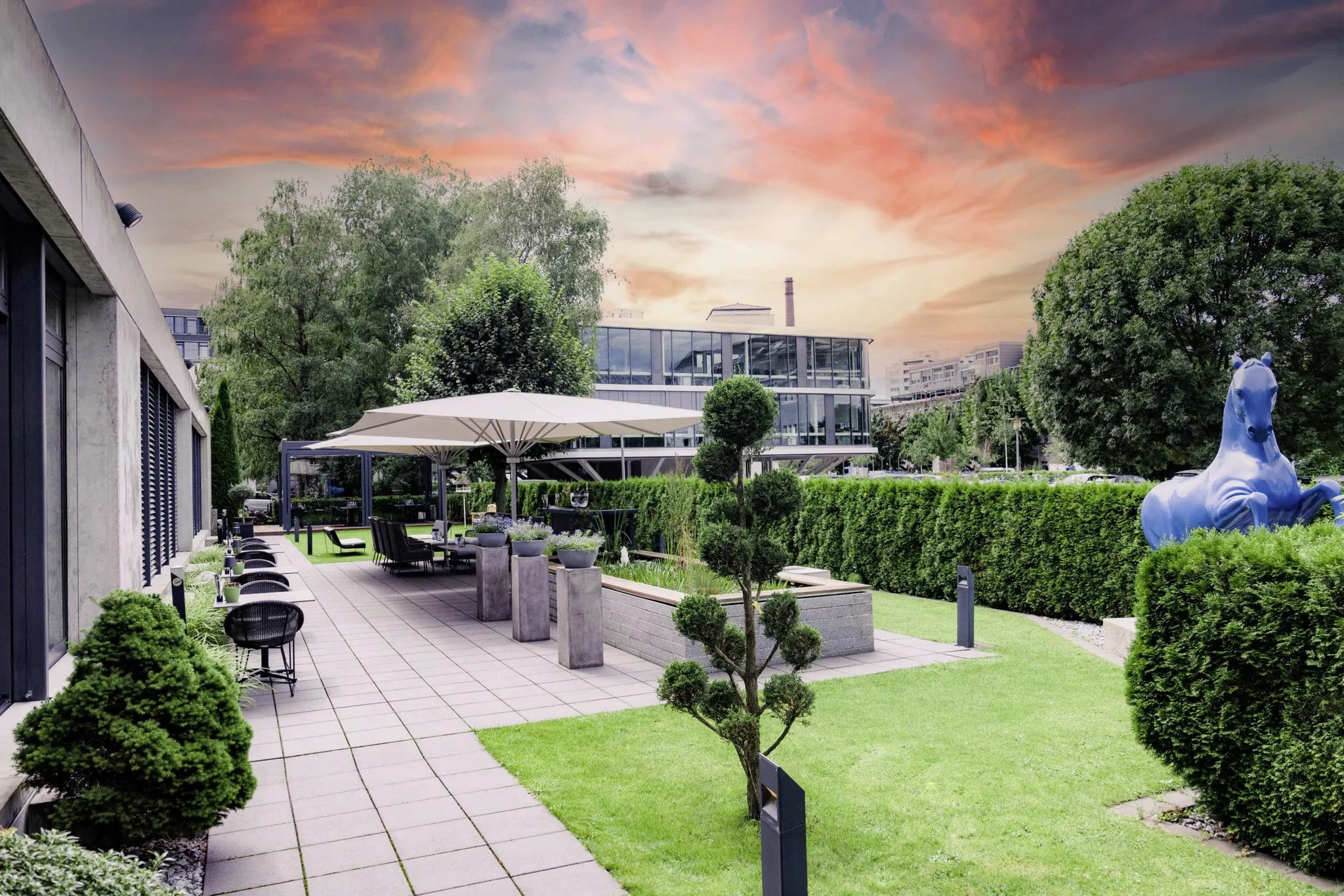 Terrasse mit Statue von Blauem Pferd vor Abendhimmel im Hotel Der Blaue Reiter