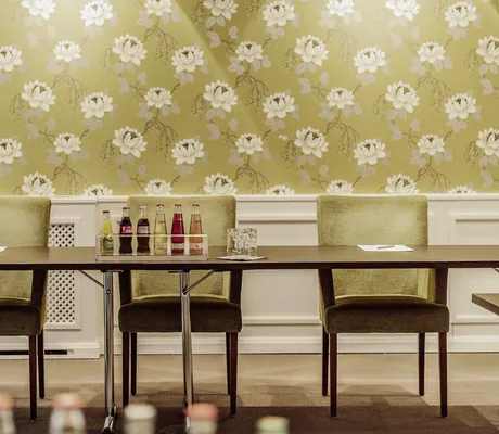 grüne Stuhlreihe vor grüner Tapete im Hotel Der Eisvogel