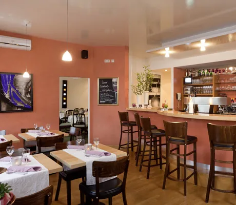 Bar im Kress Hotel mit roten Wänden und Hochstühlen