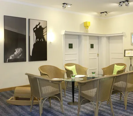 Besprechnungsraum im Kress Hotel mit Korbstühlen und gelben Kissen