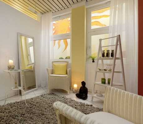 Spabereich im Kress Hotel mit gemalter Sonne an der Wand und Buchsbaum im hohen Blumentopf