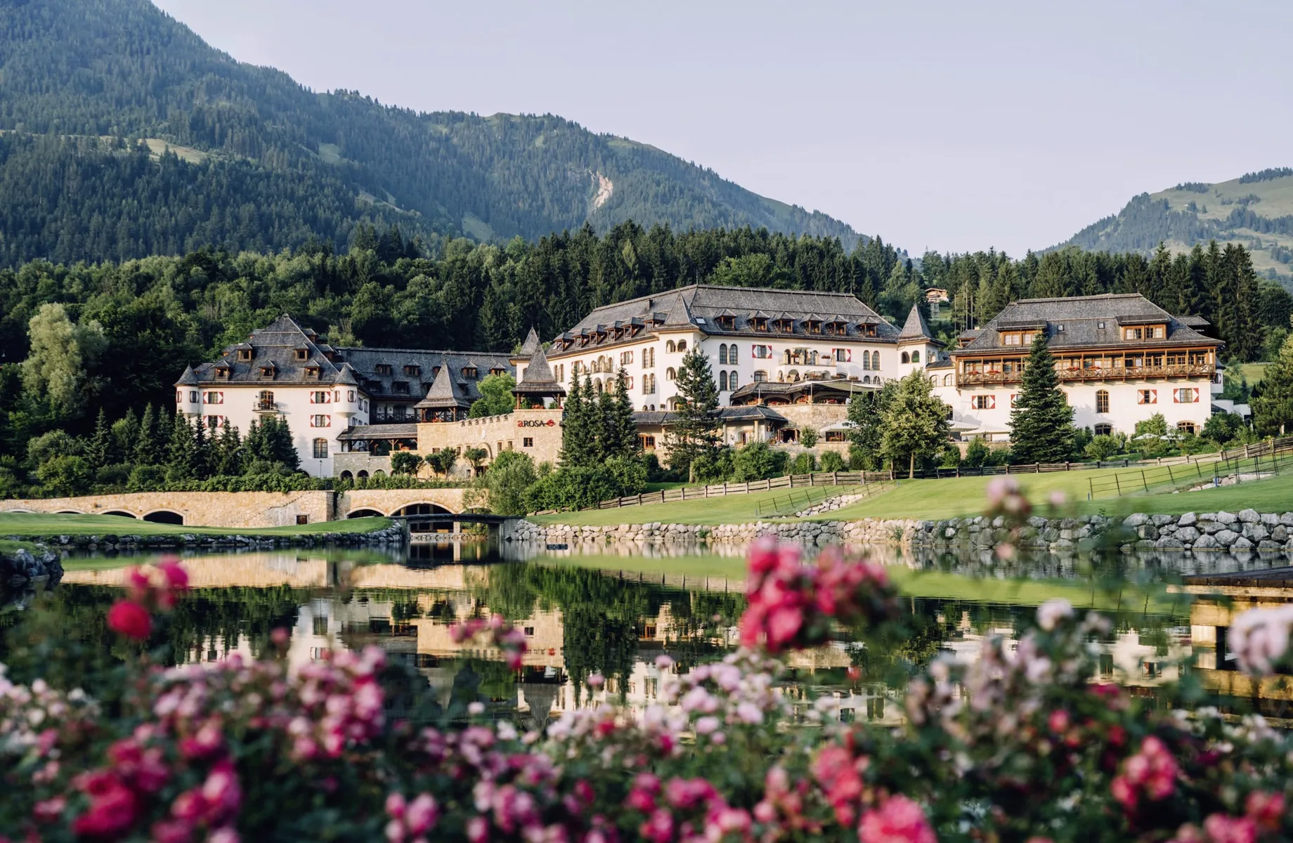 Gesamtansicht des A-ROSA Kitzbühel hinter roten Geranien