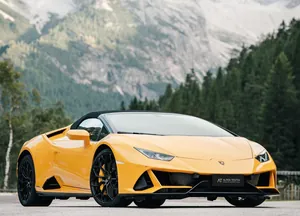 gelber Lamborghini auf einer Straße mit Bergen im Hintergrund in der Nähe des Alpen Tesitin