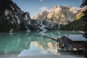 Blick auf den türkisfarbenen Pragser Wildsee in der Nähe des Alpen Tesitin mit einigen kleinen Booten und den Dolomiten im Hintergrund