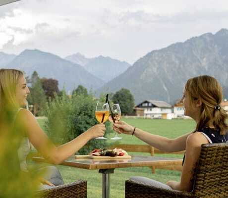 zwei Frauen prosten sich mit Aperol Sprizz zu auf der Terrasse des Best Western Alpenhof Oberstdorf
