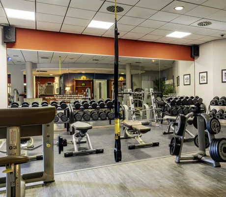 Blick in den Fitness-Club des Erlebnishotels Bell Rock mit einigen Fitnessgeräten und Hanteln