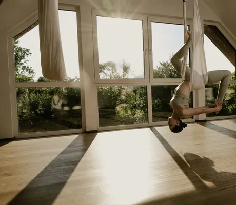 Frau macht Aerial-Yoga in beigem Tuch in Jordan's Untermühle