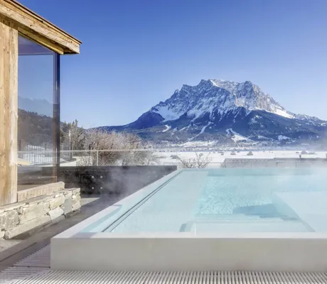 Outdoorpool des Hotel Post Lermoos mit Blick in die Winterlandschaft und auf die Zugspitze