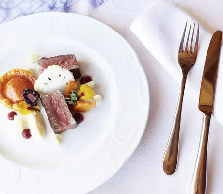 Fleischgericht mit Blüten auf weißem Teller im Hotel Prinz-Luitpold-Bad