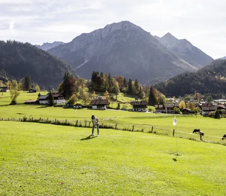 Frau spielt Krolf auf dem Platz vor dem Hotel Prinz-Luitpold-Bad