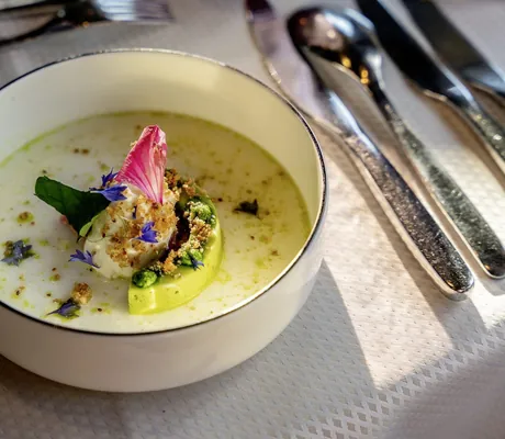 Kohlrabigericht mit Blüten auf tiefem weißem Teller auf dem Tisch in der Riederalm