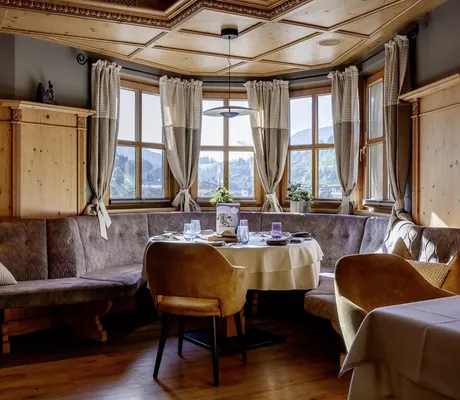 gemütlicher Erkertisch im Restaurant der Riederalm mit braunen Sitzpolstern