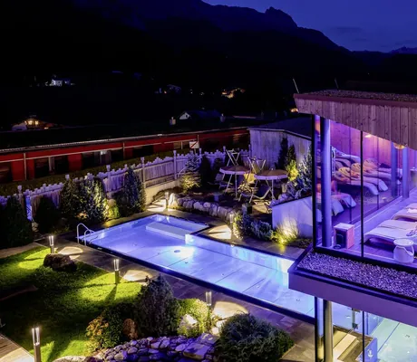 Blick auf den Spabereich und den Thermalwasserpool in der Riederalm bei Nacht