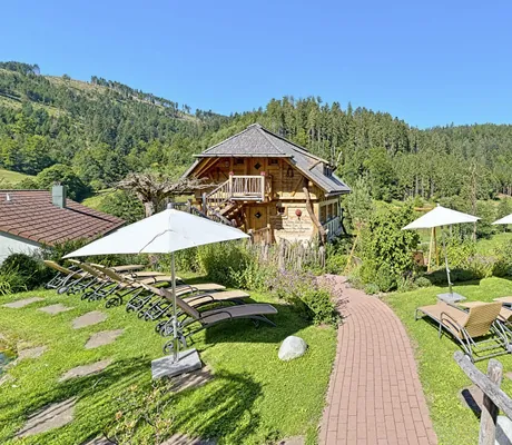 Ruheliegen vor der traditionellen Hütte im Garten des Wellnesshotel Tanne
