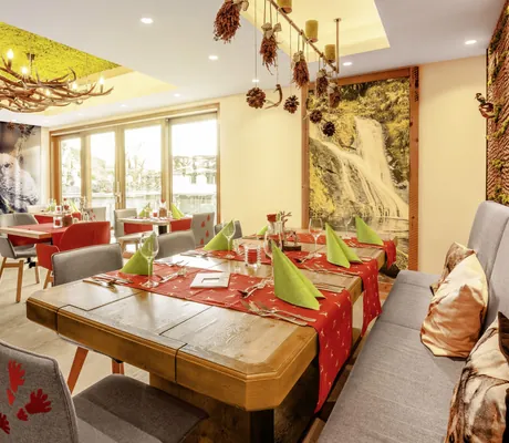 Restaurant im Wellnesshotel Tanne mit Hirschgeweih-Lampe und Eulenbild