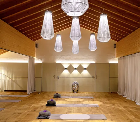 Yogaraum des Das König Ludwig Inspiration SPA unter dem Dach mit großen Deckenbalken und silberner Buddhabüste