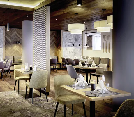 Restaurant im Das SeeMOUNT mit beigen Sesseln und grau gemusterten Trennwänden